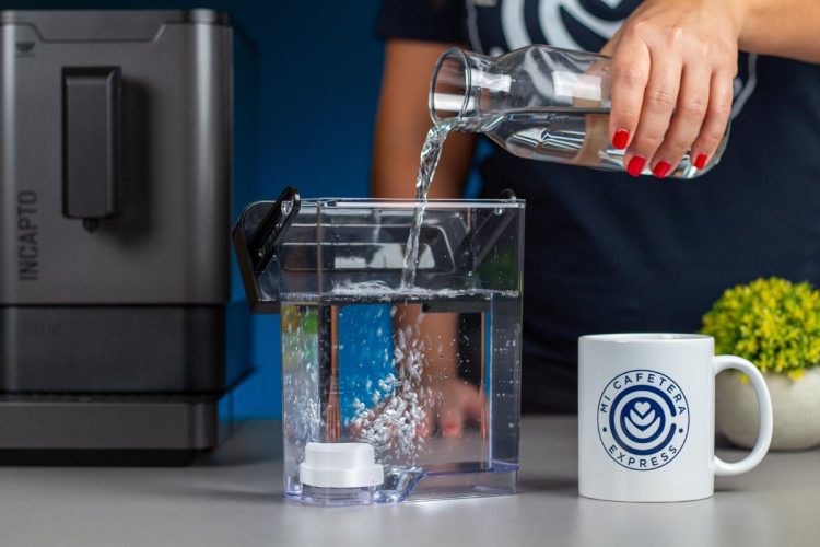 Verónica llenando el tanque de agua de la cafetera Incapto