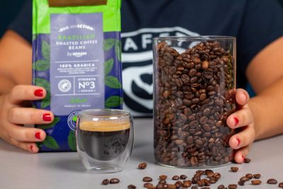 Detalle de los granos de café Amazon junto a un café