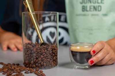 Granos de café de la variedad Jungle Blend de Incapto junto a un espresso