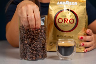 Verónica cogiendo los granos de café Lavazza situados al lado de un espresso
