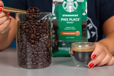 Vista en detalle de los granos de café Starbucks junto a un espresso
