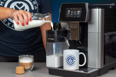 Verónica rellena el tanque de leche de la cafetera Delonghi Primadonna Soul