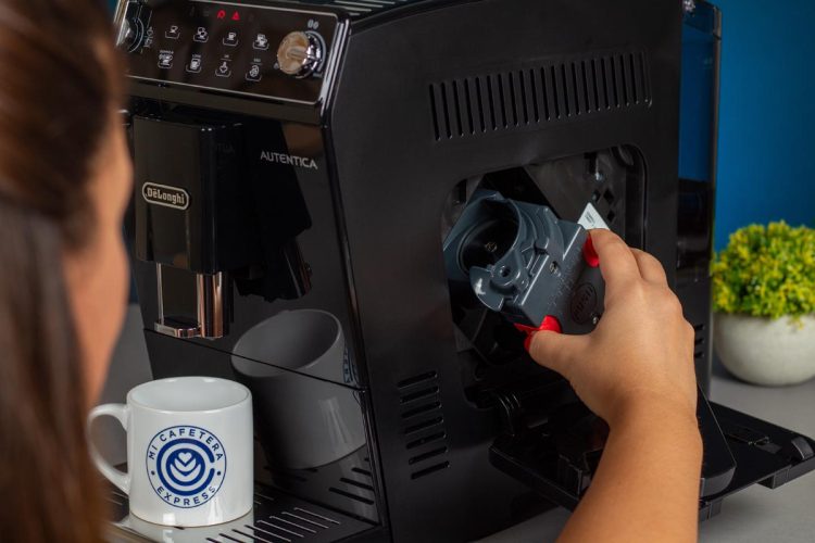 Verónica insertando el grupo de café en la cafetera Delonghi Autentica