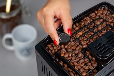 Verónica ajustando el grado de molienda de la cafetera Delonghi Magnifica S