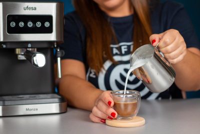 Verónica vertiendo la espuma de leche elaborada con la cafetera Ufesa Monza