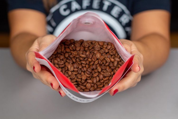 Verónica abre un paquete de Cosmos Café para enseñarnos sus granos