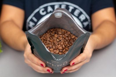 Verónica enseña los granos de café de Incapto dentro del paquete
