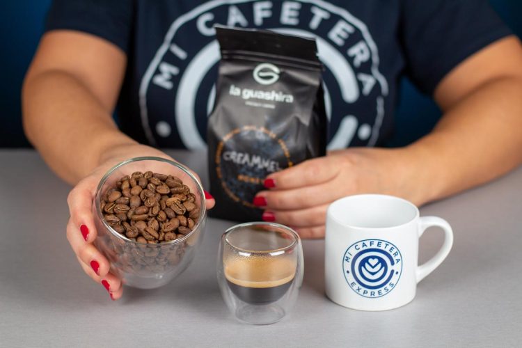 Verónica muestra los granos de café de La Guashira junto a un espresso