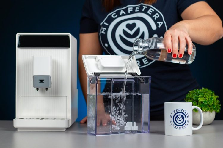 Verónica llenando el tanque de agua de la cafetera Incapto