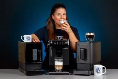 Verónica disfruta de un café junto a tres cafeteras superautomáticas compactas
