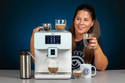 Verónica sosteniendo un lungo junto a la cafetera Cecotec 8000 y varios cafés