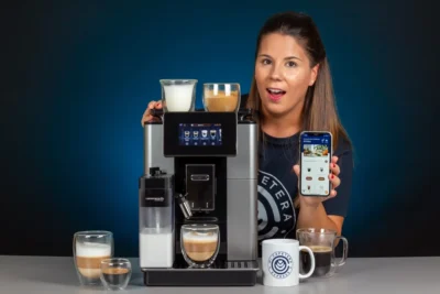 Verónica mostrando la app de Delonghi junto a la Delonghi Primadonna Soul