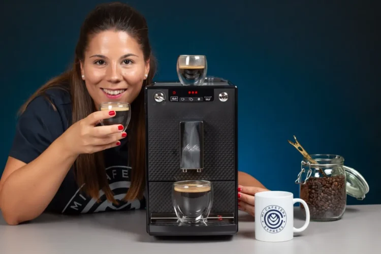 Verónica sosteniendo un espresso junto a la cafetera Melitta Caffeo Solo